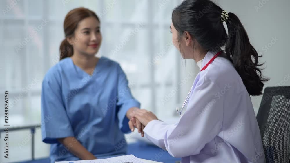 A woman in a white lab coat is talking to a woman in a blue hospital gown. The woman in the blue gown is holding a piece of paper A woman in a white lab coat is talking to a woman in a blue hospital gown. The woman in the blue gown is holding a piece of paper