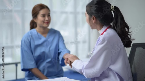Wallpaper Mural A woman in a white lab coat is talking to a woman in a blue hospital gown. The woman in the blue gown is holding a piece of paper Torontodigital.ca