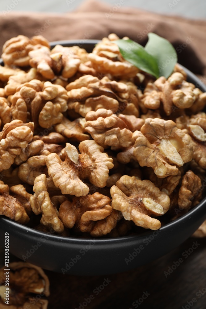 Fresh ripe walnuts in bowl on table, closeup Fresh ripe walnuts in bowl on table, closeup