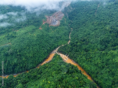 A breathtaking drone shot of Khaddum Hills, capturing a rain-fed river dividing into two streams, creating a natural reverse Y pattern as it flows through the misty, green landscape.
