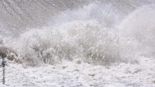row of chute dentate blocks in concrete water spillway channel slope slowing down splashing flow of water running down.