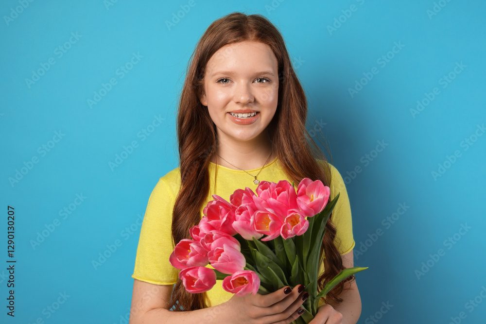 Beautiful teenage girl with bouquet of tulips on light blue background Beautiful teenage girl with bouquet of tulips on light blue background