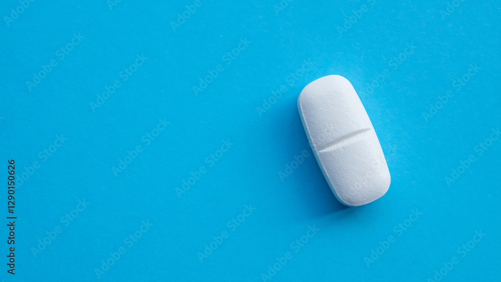 White medicine pill tablet on blue background White medicine pill tablet on blue background