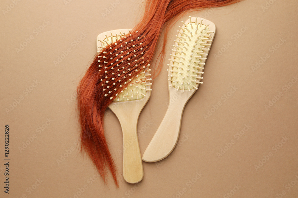 Fototapeta premium Wooden brushes and lock of hair on beige background, flat lay