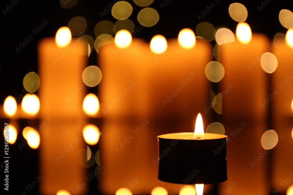 Burning candles on mirror surface in darkness, closeup. Bokeh effect Burning candles on mirror surface in darkness, closeup. Bokeh effect