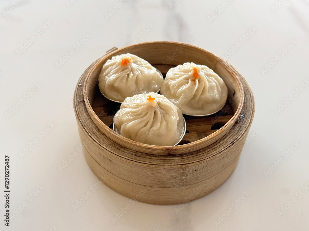 steamed Xiao long bao Shanghai small meat dumpling in bamboo basket with ginger vinegar sauce on white table chinese dim sum menu banquet restaurant halal food