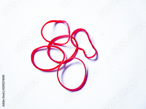 Obraz na plátně Close-up red rubber bands against a plain white background