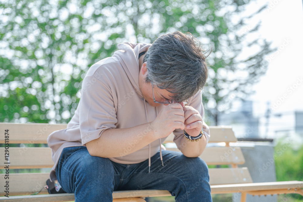 ベンチで座る私服男性 ベンチで座る私服男性