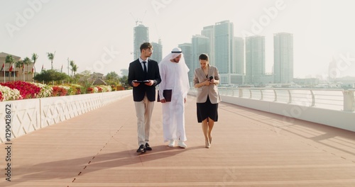 Canvas Print A man in traditional white Arab clothes with a laptop in his hands communicates