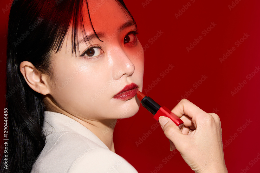 Obraz premium 赤い口紅のメイクアップをした若い女性のシックなポートレート