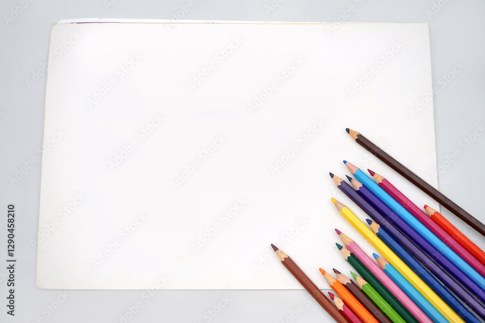 Studio shot of flatlay photo of kids coloring pencils on white paper background banner, copy space. Back to school concept. Studio shot of flatlay photo of kids coloring pencils on white paper background banner, copy space. Back to school concept.