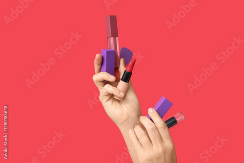 Female hand holding red lip...