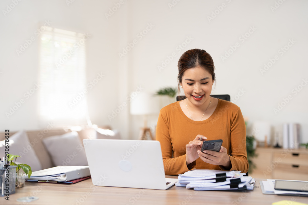 Satisfied entrepreneur using online mobile app. Business woman sitting at desk in living room, using mobile phone, looking at screen and smiling. Digital technology concept Satisfied entrepreneur using online mobile app. Business woman sitting at desk in living room, using mobile phone, looking at screen and smiling. Digital technology concept
