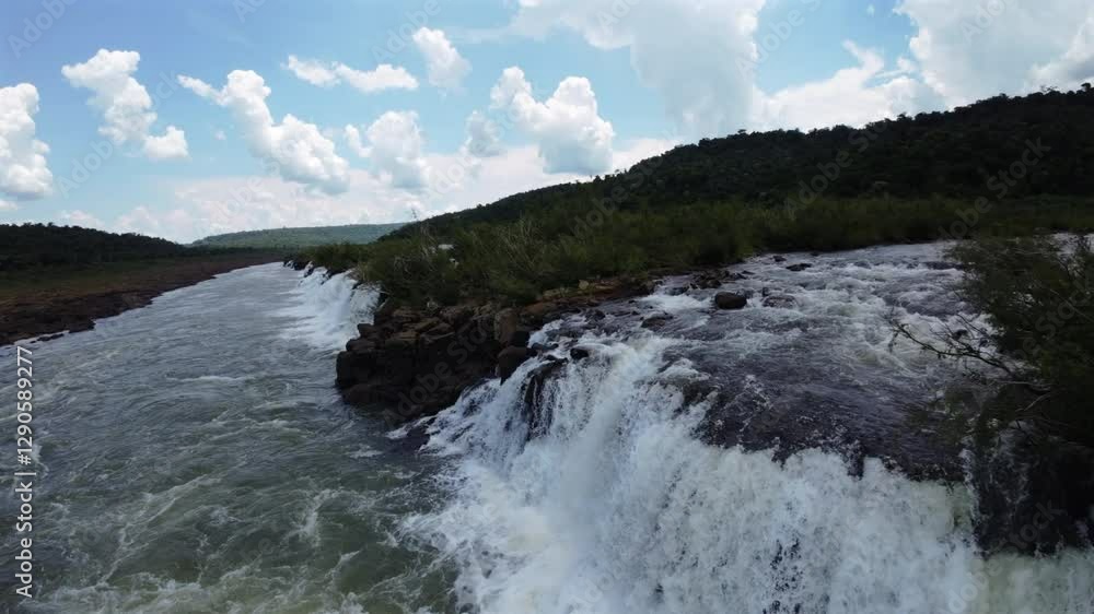 Sideways drone movement of the Mocona Falls with gentle rapids flowing under blue skies, Argentina. Sideways drone movement of the Mocona Falls with gentle rapids flowing under blue skies, Argentina.