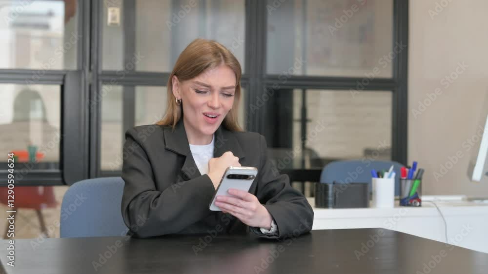 Young Businesswoman Celebrating Success on Phone in Office Young Businesswoman Celebrating Success on Phone in Office