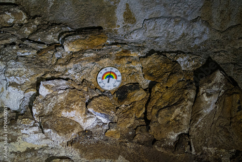 A thermometer affixed to a rugged rock wall, capturing the intersection of nature and human technology in an intriguing display of temperature measurement. photo