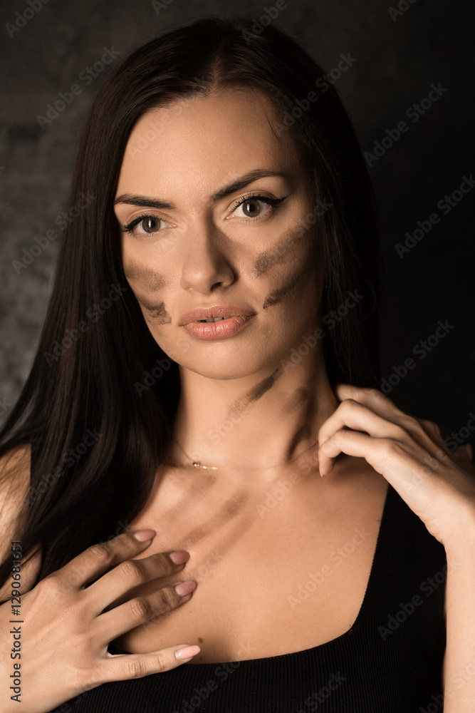 Beautiful woman applying camouflage military makeup to her body