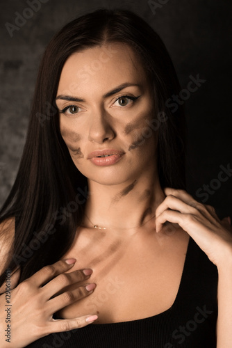 Obraz na płótnie Beautiful woman applying camouflage military makeup to her body w salonie