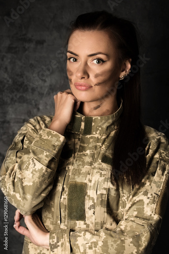 Obraz na płótnie Beautiful military woman in Ukrainian military uniform with camouflage makeup on her face w salonie