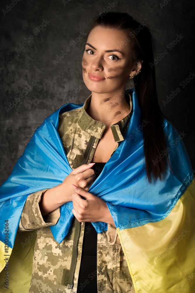 Beautiful young military woman in military uniform with camouflage makeup on her face with Ukrainian flag