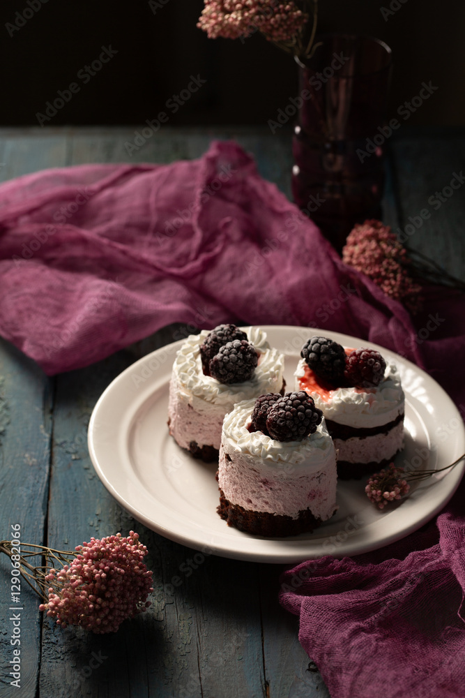 Delicious cream cakes with blackberries on a plate