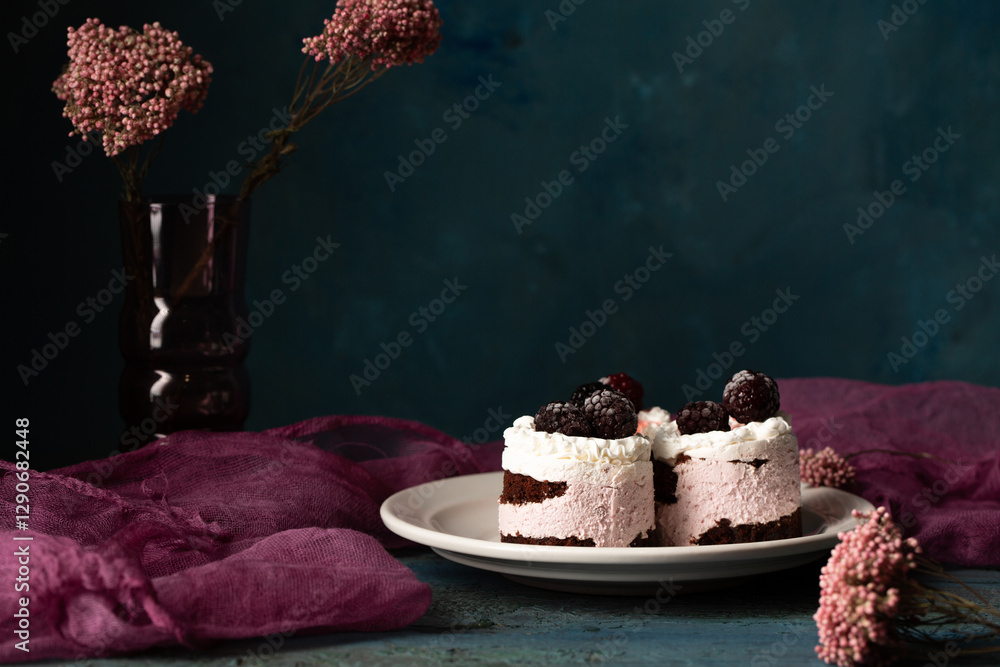 Delicious cakes with frozen blackberries on a white plate. Still life in a rustic style