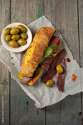 Obraz na płótnie Burger with ciabatta with turmeric, bastrum and olives, top view w salonie