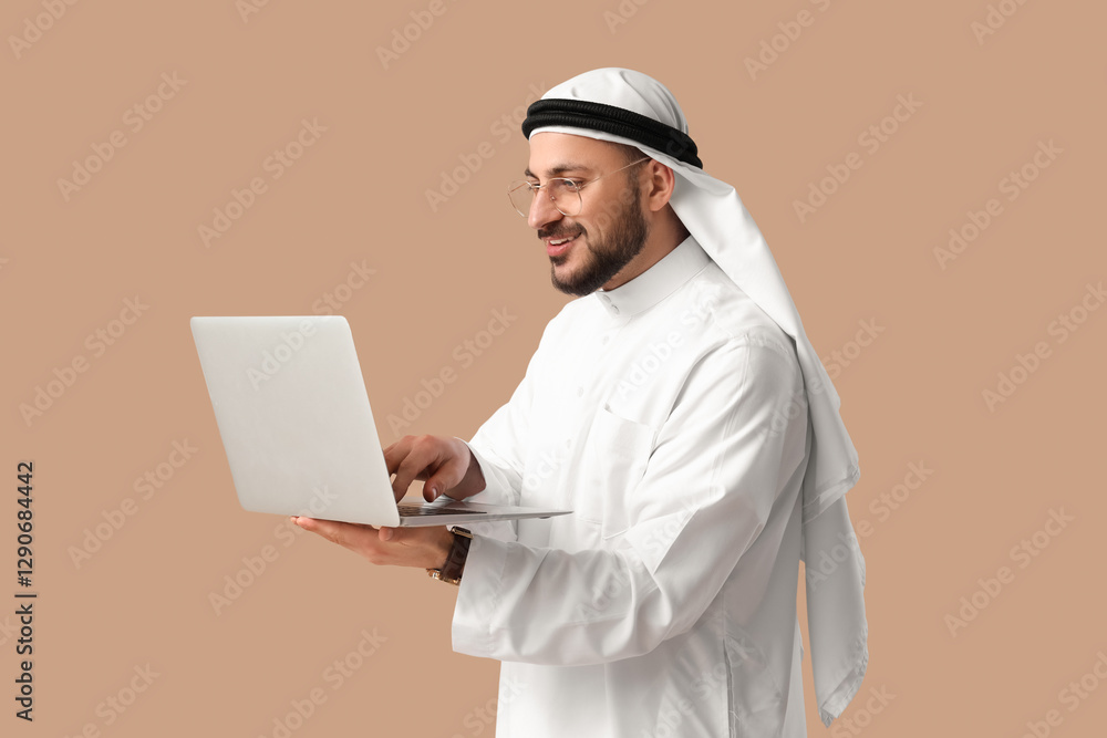 Arab businessman working with laptop on beige background Arab businessman working with laptop on beige background