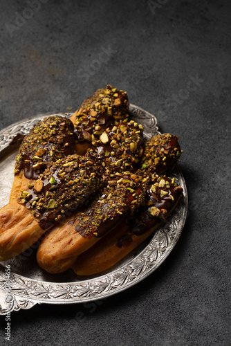 Chocolate and pistachio eclair cookies on a metal plate