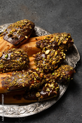 Obraz na płótnie Chocolate and pistachio custard cookies on a vintage metal plate, close-up w salonie