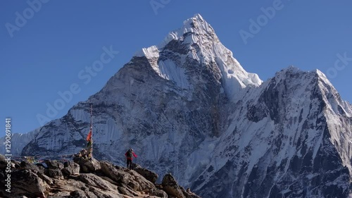 Majestic Mount Everest towers over a mountaineer standing on Nangkartshang Peak, showcasing the challenging yet rewarding pursuit of conquering Himalayas
