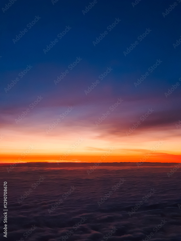 A breathtaking sunrise above the clouds, painting the sky with warm hues of orange, pink, and deep blue A breathtaking sunrise above the clouds, painting the sky with warm hues of orange, pink, and deep blue