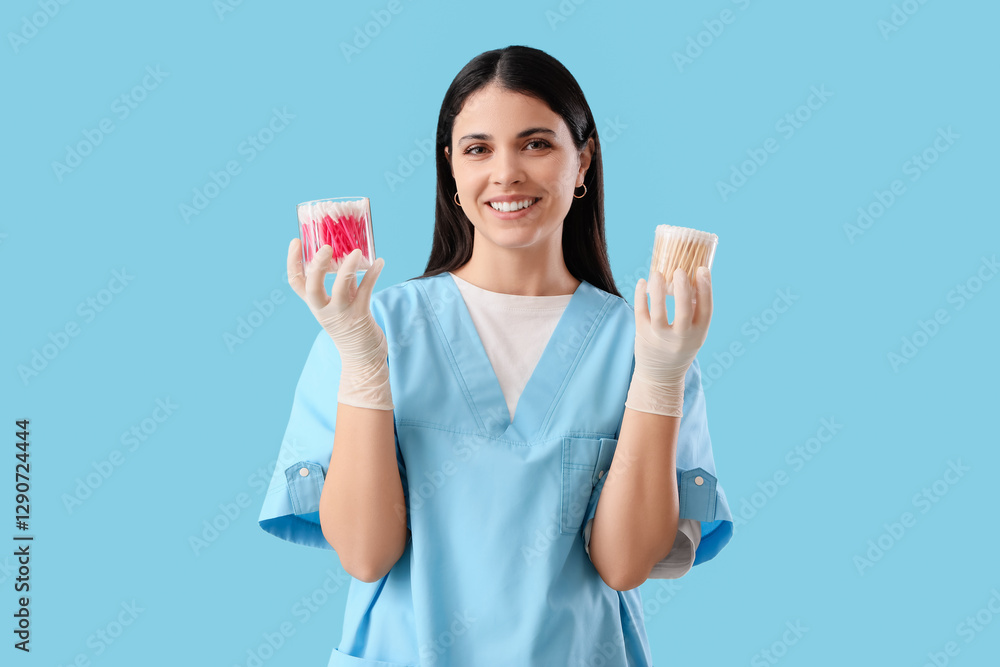 Female doctor with cotton buds on blue background Female doctor with cotton buds on blue background