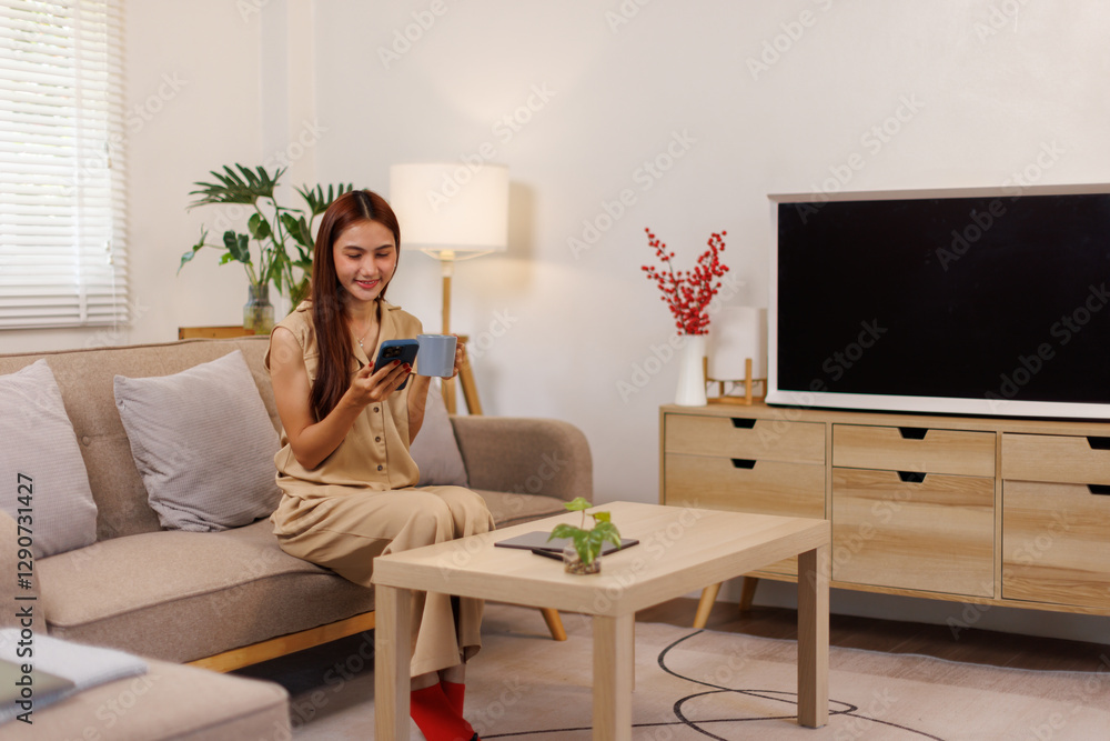 Beautiful confident asian business woman sitting on cozy couch, using funny mobile apps in living room. Woman at Home, Doing Online Shopping, Messaging Friends, Posting on Social Media Beautiful confident asian business woman sitting on cozy couch, using funny mobile apps in living room. Woman at Home, Doing Online Shopping, Messaging Friends, Posting on Social Media