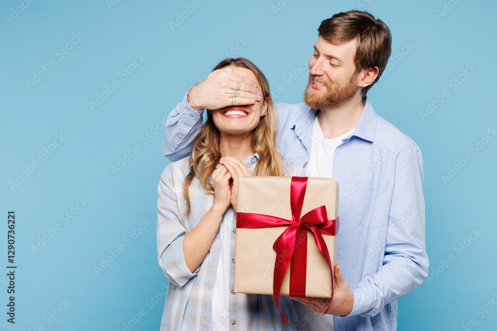 Obraz premium Young couple two friends family man woman wear shirt casual clothes together give present box with gift ribbon bow cover eyes isolated on pastel plain light blue background studio. Lifestyle concept.