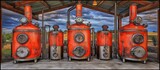 Rustic distillery stills under a dramatic sky.  Possible use advertising, editorial
