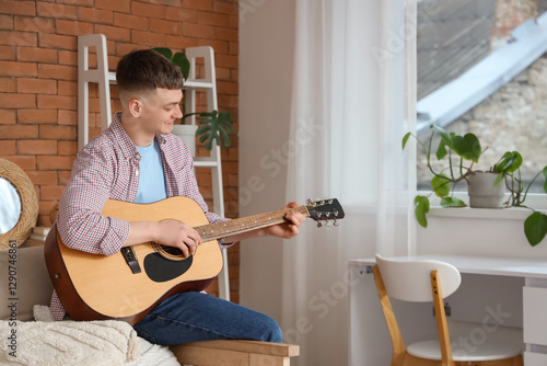 Young man playing guitar at...