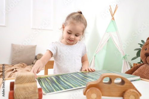 Cute little girl reading fa...