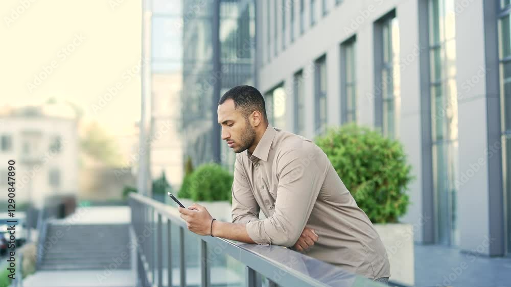 Side view Handsome employee business man using mobile phone background office building on city street outside Confident male businessman in shirt browsing use smartphone typing chatting social media Side view Handsome employee business man using mobile phone background office building on city street outside Confident male businessman in shirt browsing use smartphone typing chatting social media