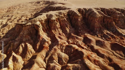 A girl walking through the Mars-like hills of Tsagaan Suvarga, Mongolia, captured in breathtaking aerial drone footage at sunset.