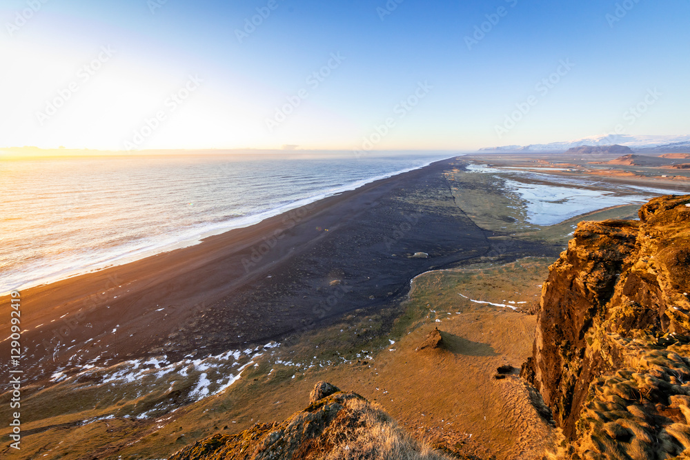 View of black sand beach at sunset with dramatic cliffs and ocean, Dyrholaey, Vik i Myrdal, Iceland. View of black sand beach at sunset with dramatic cliffs and ocean, Dyrholaey, Vik i Myrdal, Iceland.