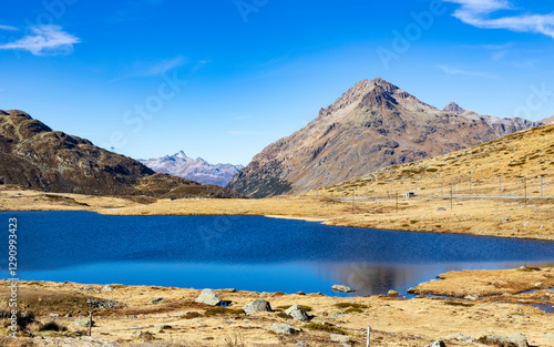 View of serene Lago Bianco surrounded by majestic autumn Alps and rocky terrain, Samedan, Switzerland. photo