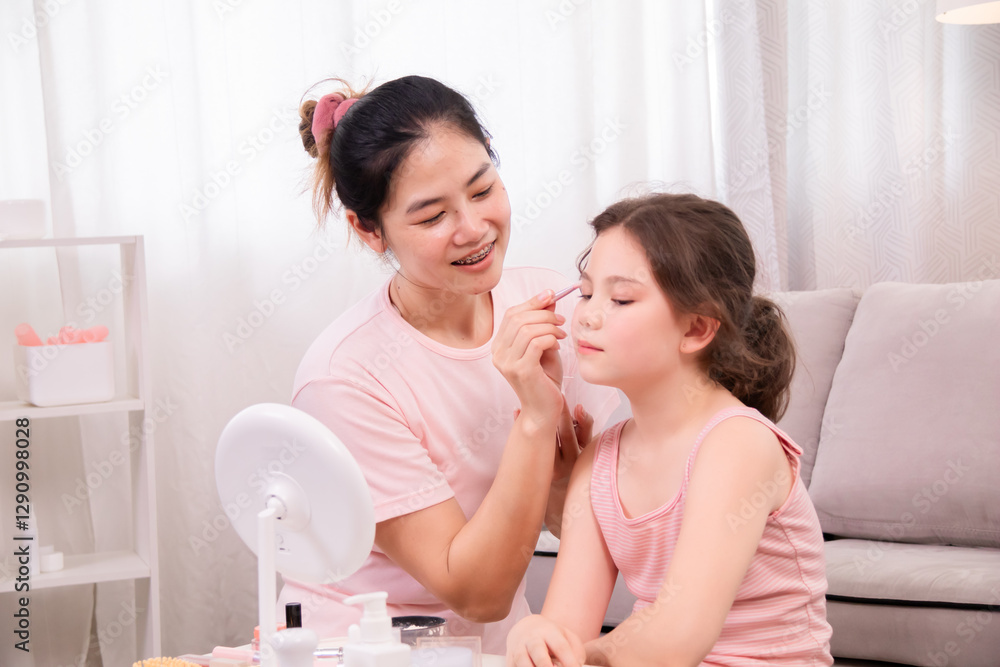 Asian caring mother teaches adorable daughter about beauty and self-care by gently applying makeup in warm, homey atmosphere, bond of parenting, embodies love, and family warmth, spending time at home Asian caring mother teaches adorable daughter about beauty and self-care by gently applying makeup in warm, homey atmosphere, bond of parenting, embodies love, and family warmth, spending time at home