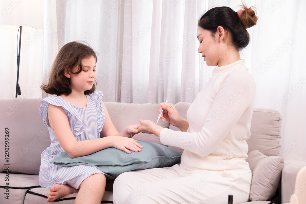 Young mother carefully paints her young daughter's nails at home, creating a special bonding moment of self-care and relaxation, adorable girl enjoys gentle manicure from her caring mother with love. Young mother carefully paints her young daughter's nails at home, creating a special bonding moment of self-care and relaxation, adorable girl enjoys gentle manicure from her caring mother with love.
