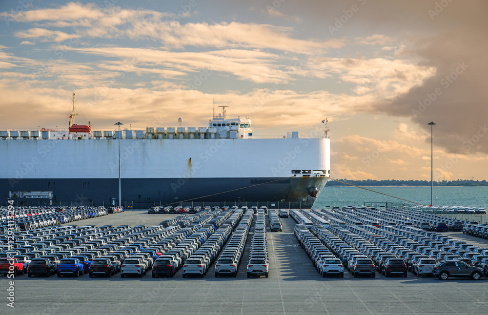 Vast car shipment at port with cloudy sky and calm waters