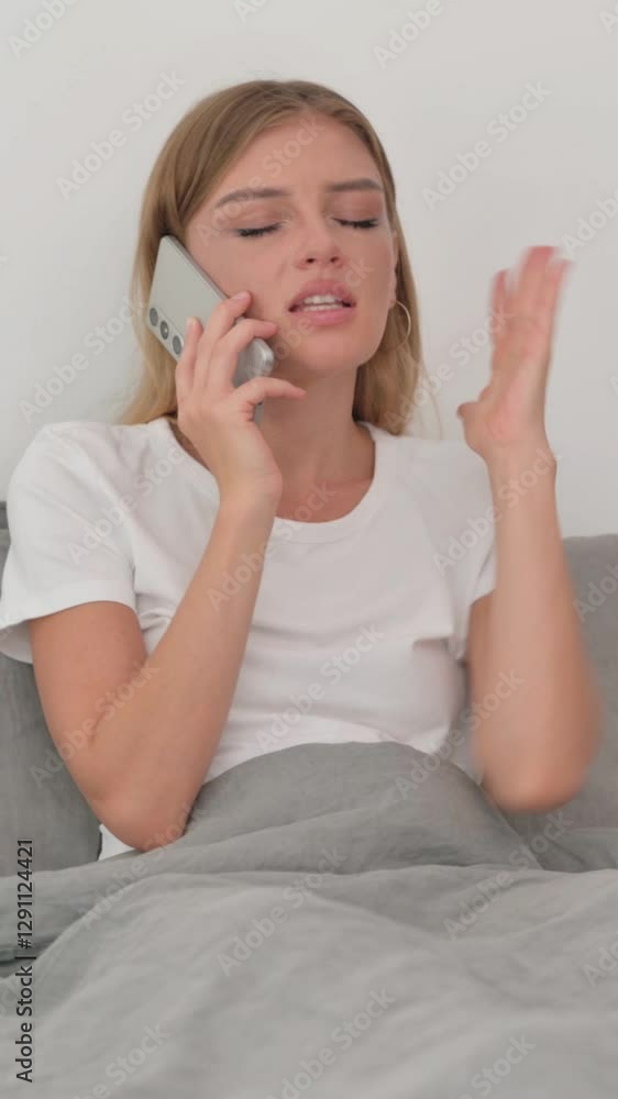 Angry Young Woman Talking on Phone while in Bed Angry Young Woman Talking on Phone while in Bed