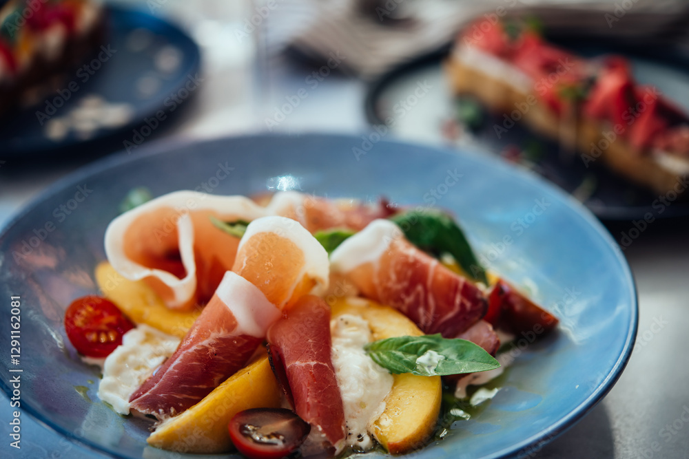A table served for a dinner with prosciutto salad and roastbeef bruschetta in a bar or restaurant.