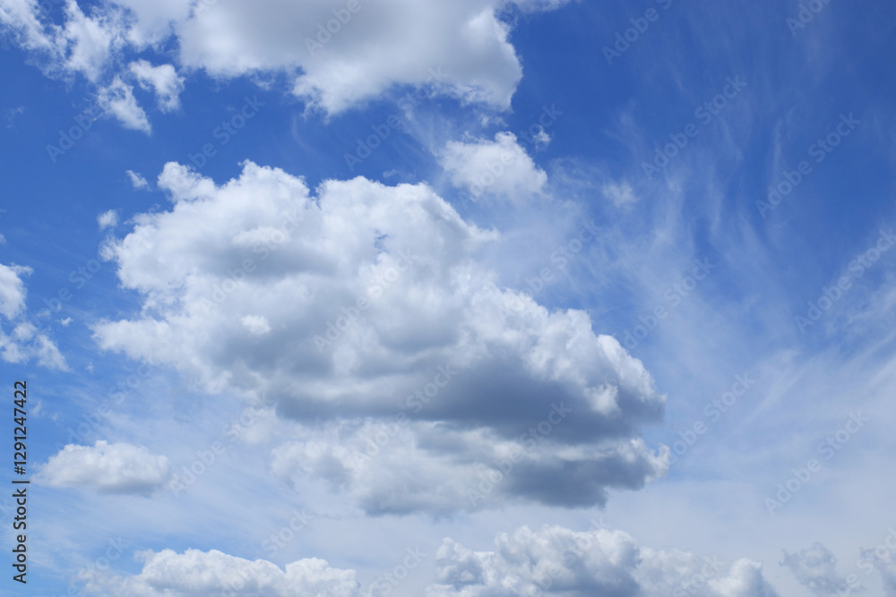 Obraz premium White clouds in a blue sky. Soft cloudscape with bright, airy formations, ideal for backgrounds, nature themes, and weather concepts.