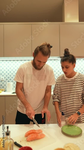 A couple enjoys the delightful experience of cooking together in their stylish modern kitchen