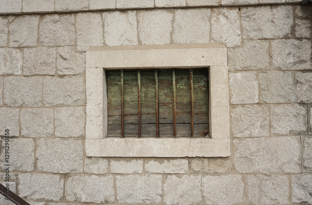 Window with metal bars. Traditional Croatian house facade. White stones wall. Window with metal bars. Traditional Croatian house facade. White stones wall.
